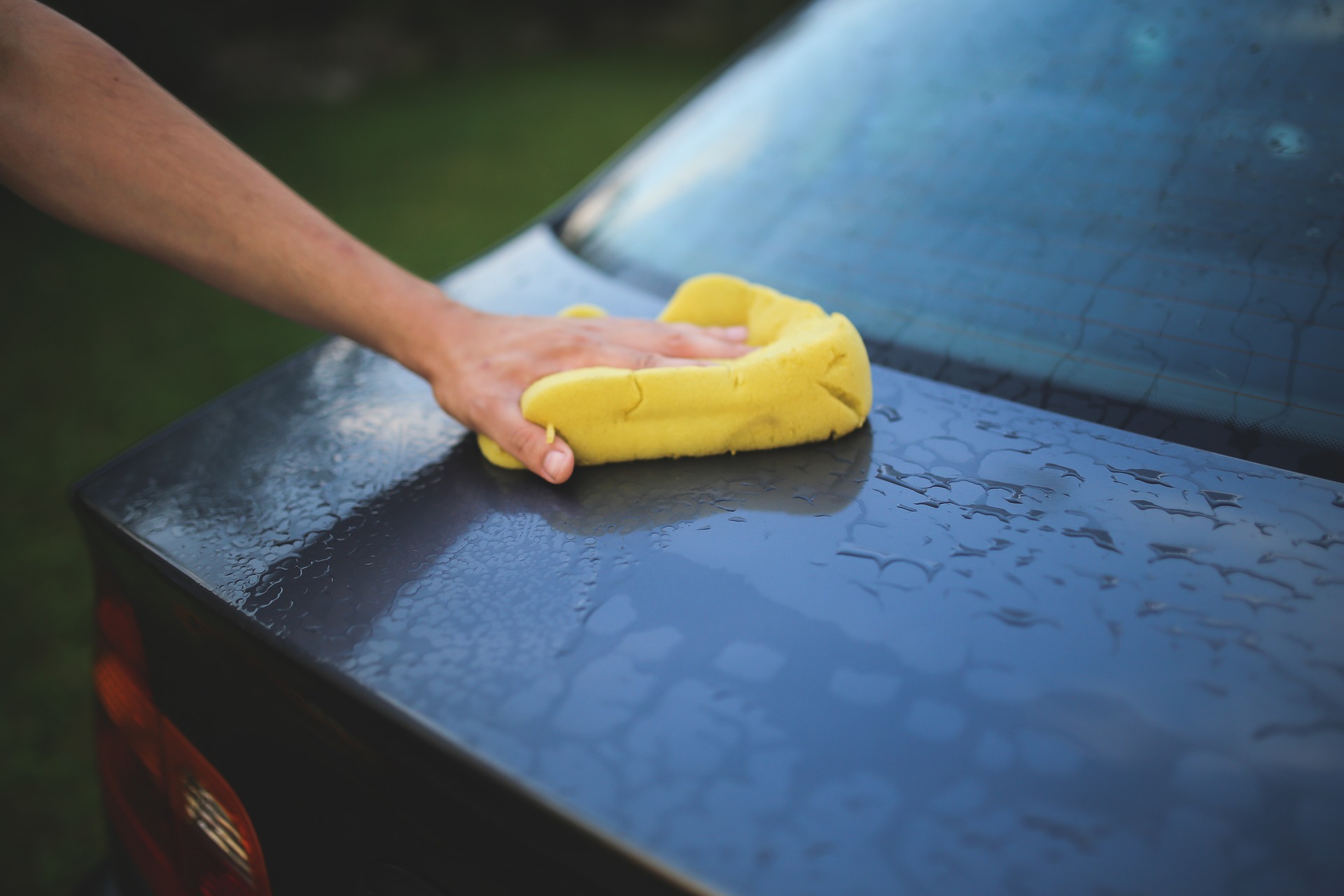 Yellow sponge washing a black car Decatur Autowash better touchfree wash