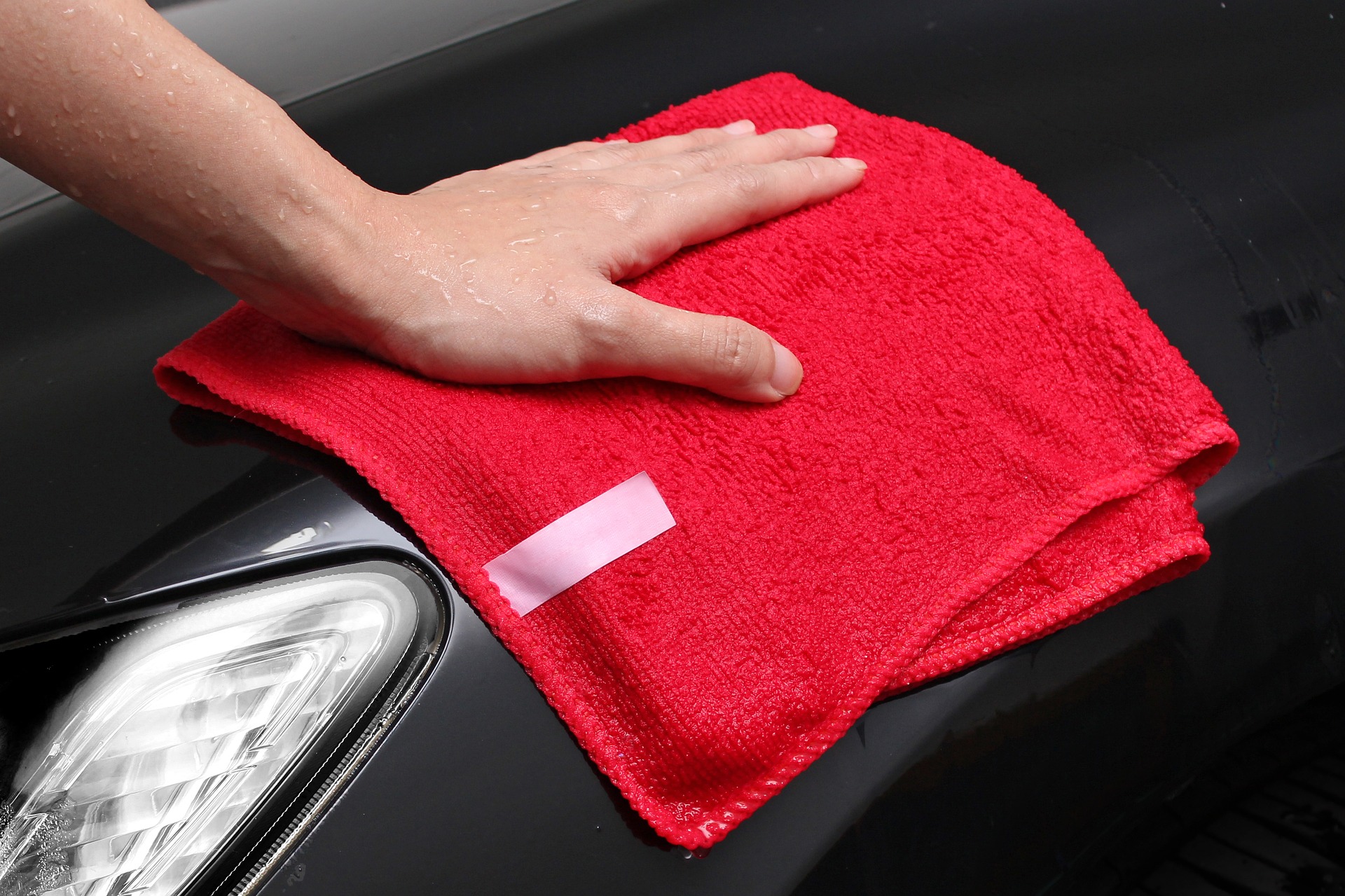 Red towel drying a black car Decatur Autowash good touchfree wash
